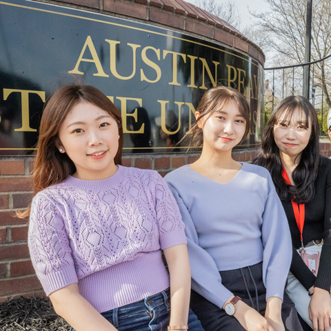 Japanese exchange students in front of the Austin Peay sign on College Street.