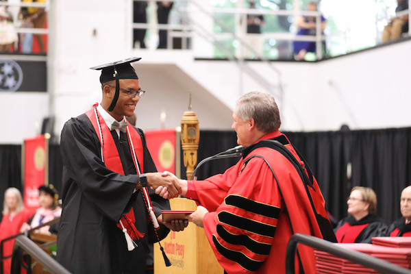 APSU President Mike Licari congratulates GYO grad Malachi Johnson.
