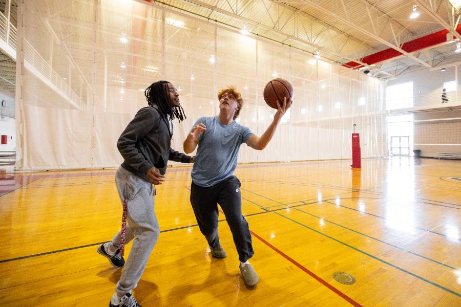 two students playing basketball at the Foy Center