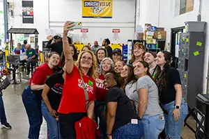 Faculty, staff, and students taking a group selfie at their service project