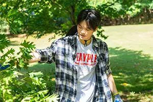Student helping to clean up limbs at a park