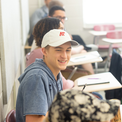 Student in APSU ball cap sitting in a classroom