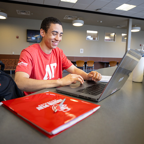 Student in the classroom taking notes  on their laptop