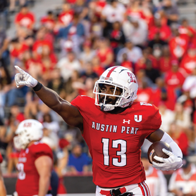 Player pointing up into the stands while holding the ball after a successfull play.