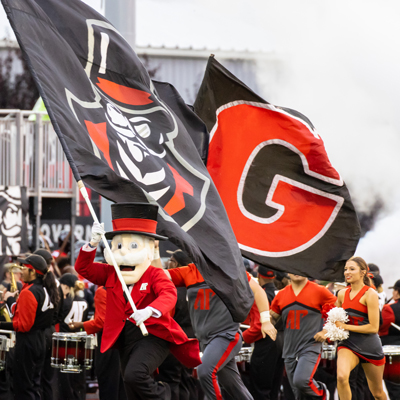 Gov Mascot running with Flag