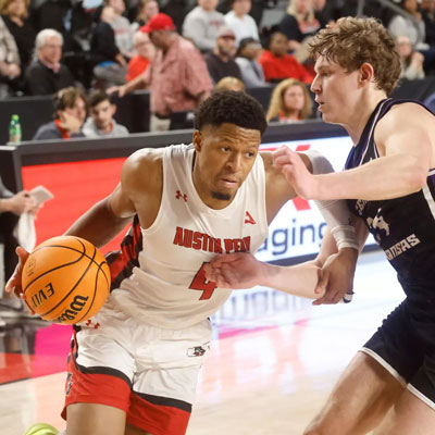 player trying to push pash the guard to go for a layup.