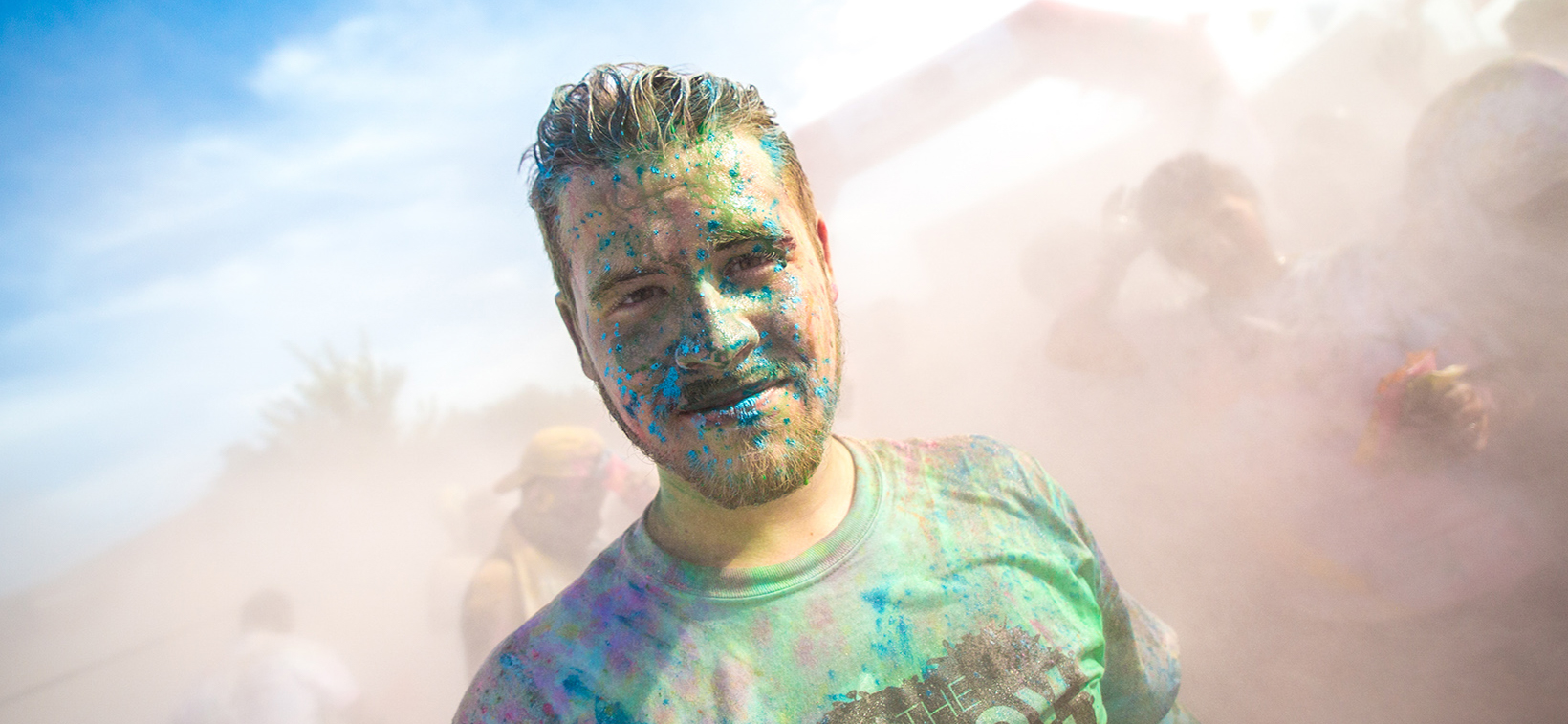 Student stands in intramural field after color run
