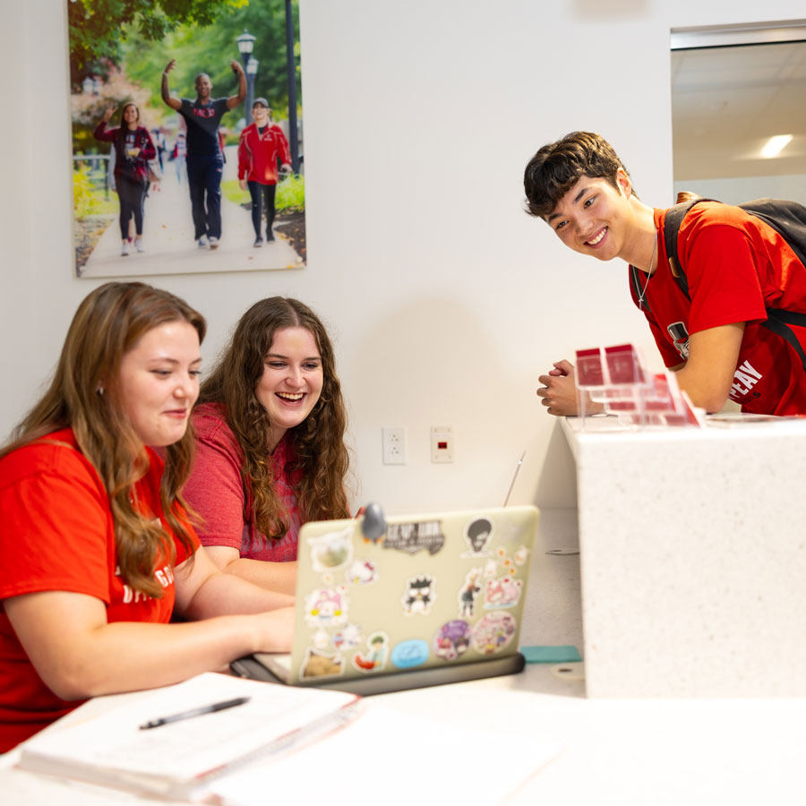 Student discussing their course work at a welcome desk for the College of Business