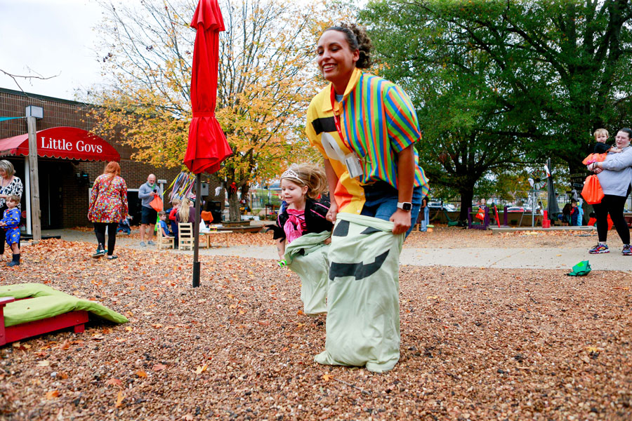 Staff and children participating in a sack race