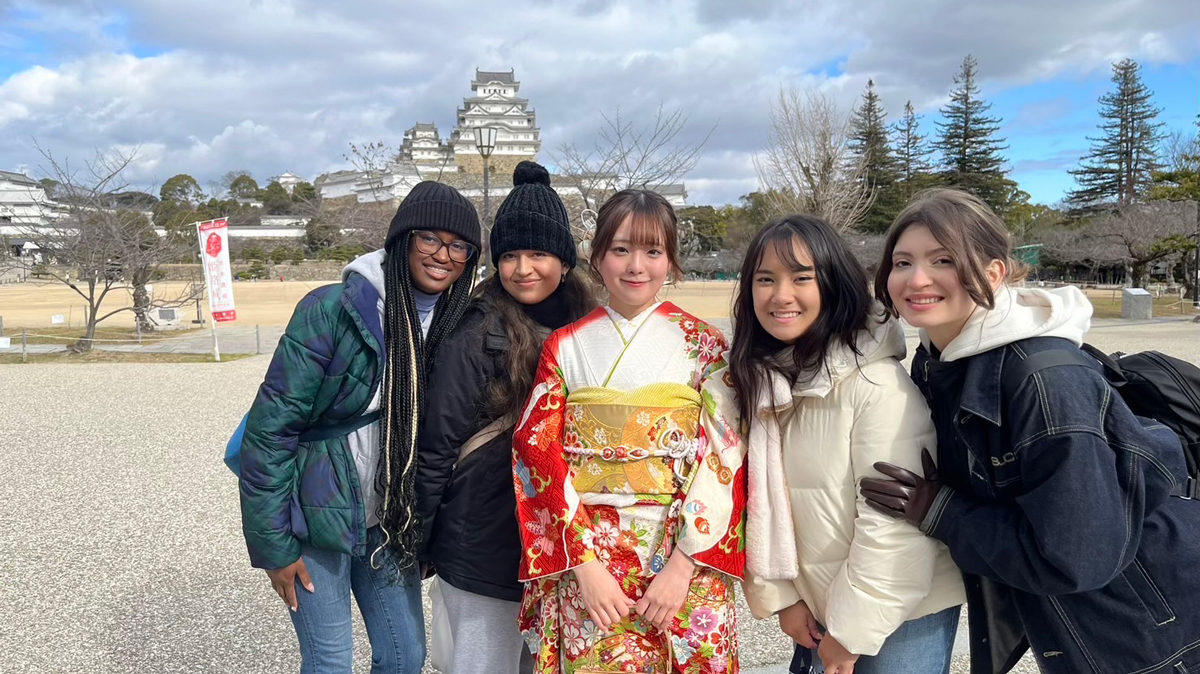 Students posing with locals after a ceremony.