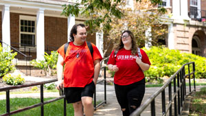 Students walking around outside with their backpacks on.