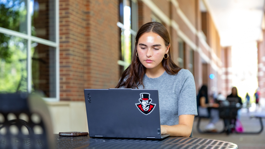 Student working on their laptop outside the University Center