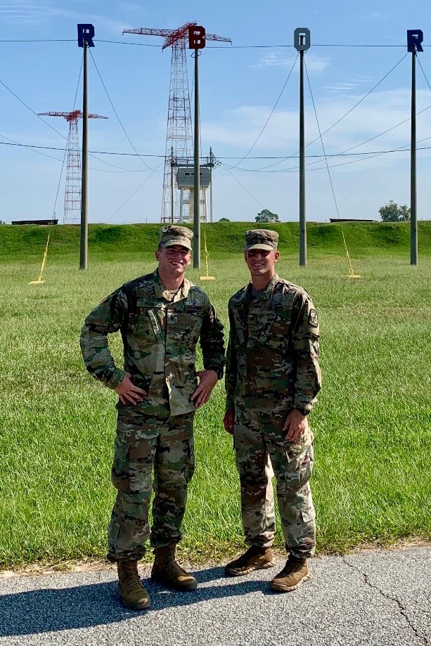 Alden Marvin, right, stands in front of the Army Airborne School towers.