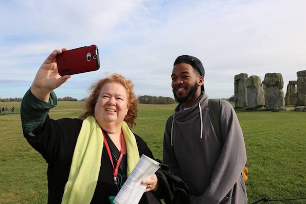 Comm professor and student pose for photo in front of stone henge