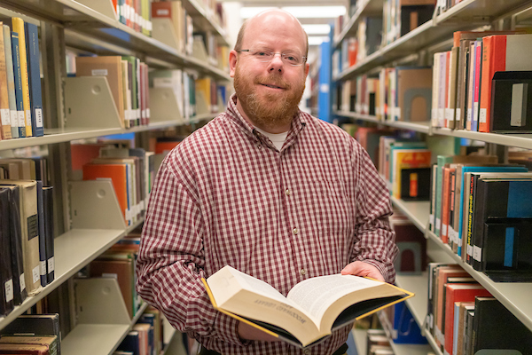 Dr. Kevin Harris poses in library