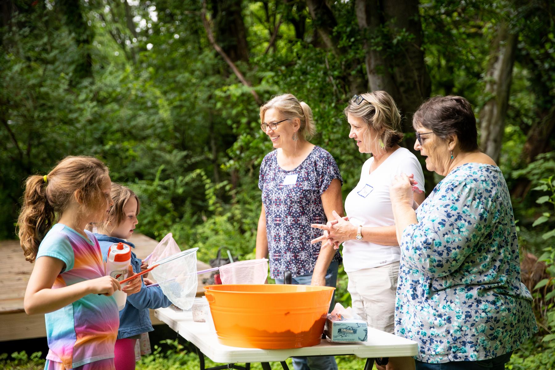 Volunteers teach children about using soil during APSU's Pollinator Week event.