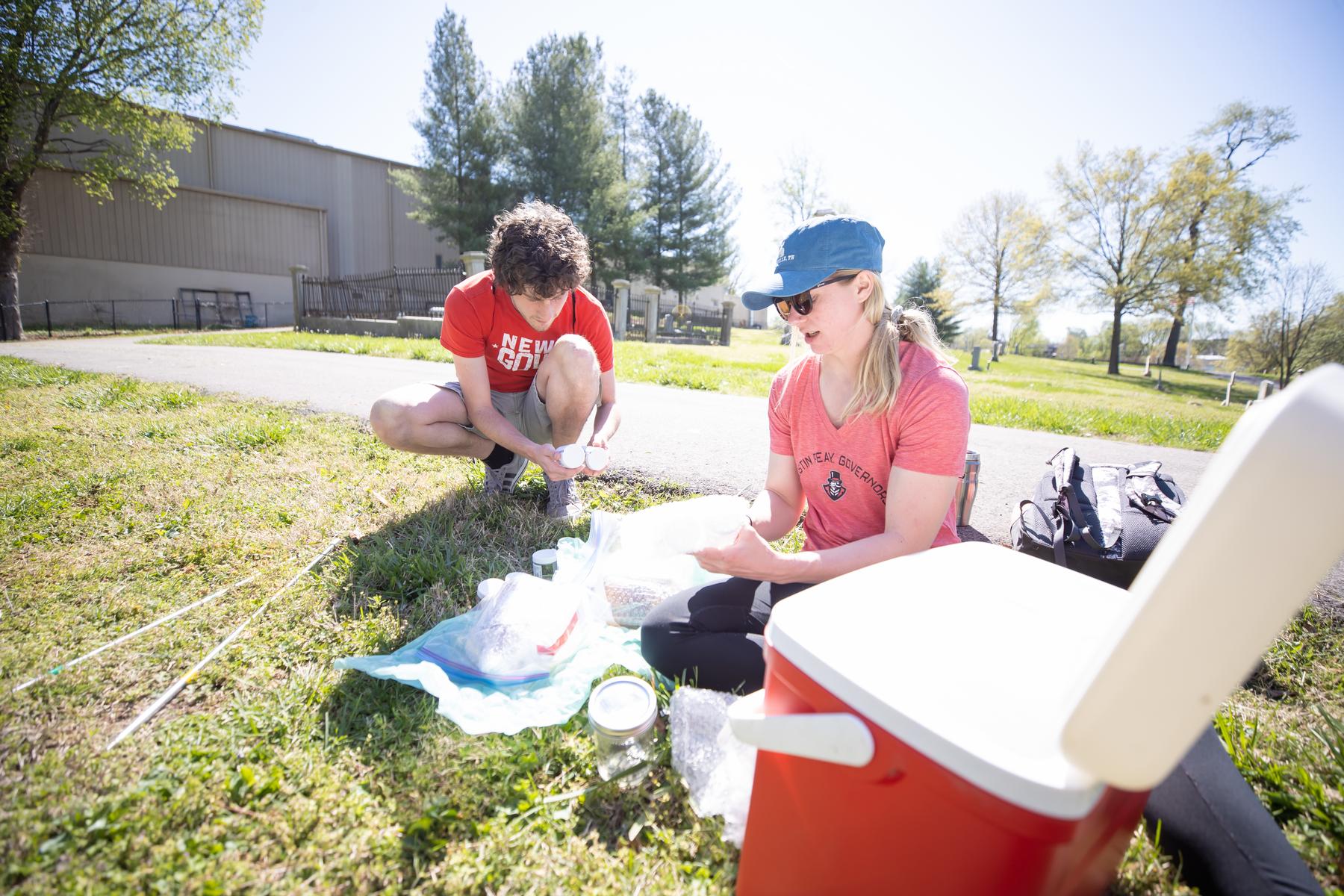 Patrick Richardson and Dr. Heather Tillewein prepare jars to collect soil samples. 