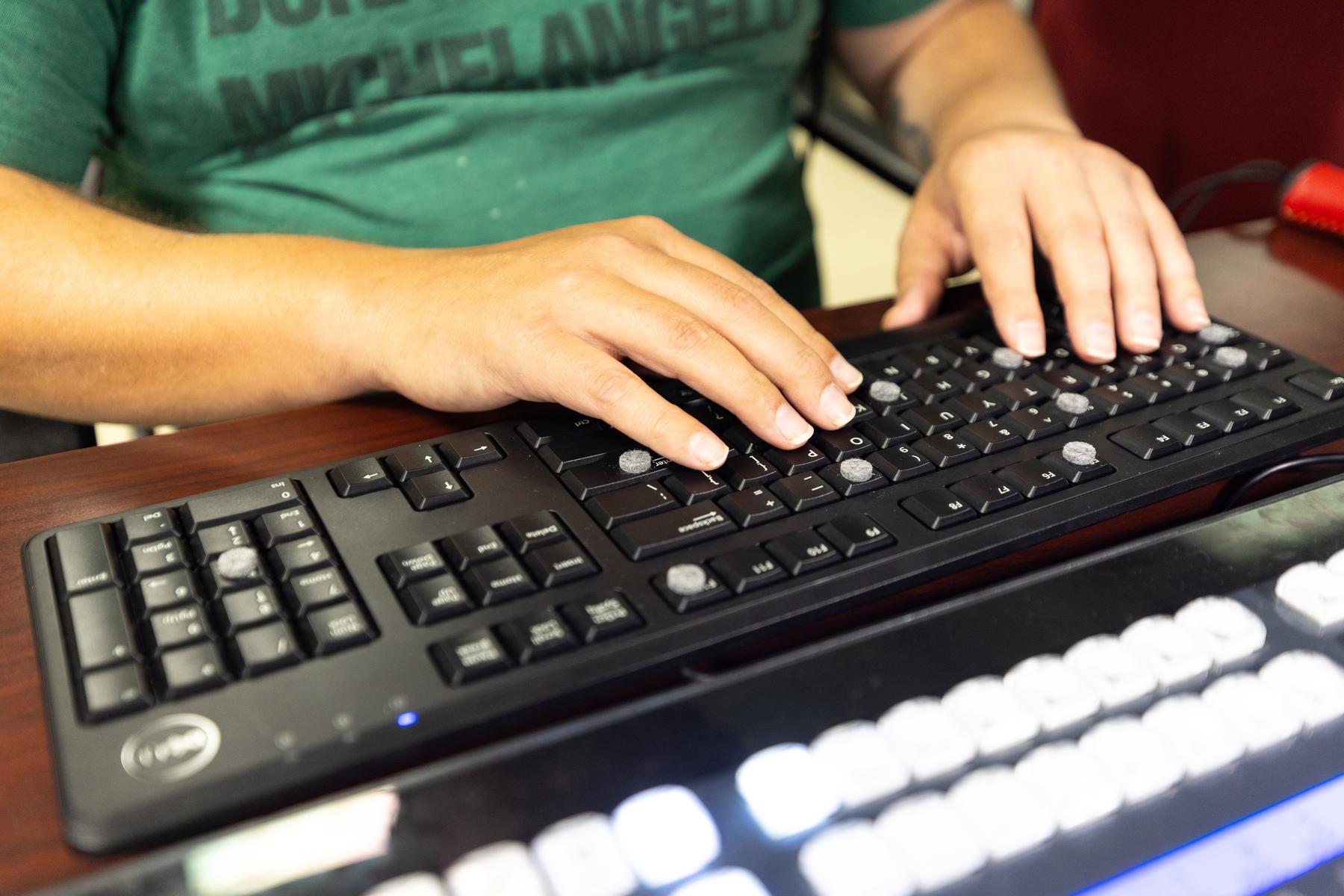 Freshman sports communication major Joseph Brock uses bump dots to map out a keyboard.