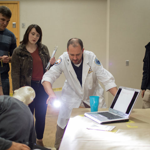 Students around instructor during investigative class