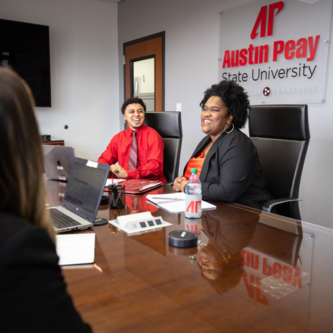 Students in a conference room talking.