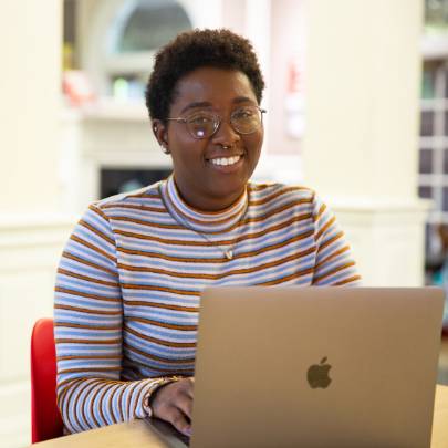 Student poses for photo in harned building