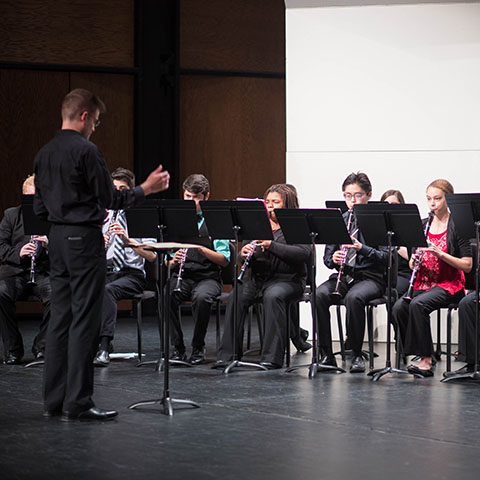 Music student conducts ensemble during performance