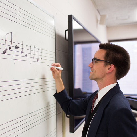 Music student writing on dry erase board