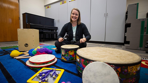Professor posing with drums in classroom 