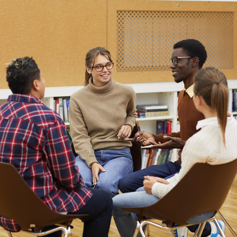 Students sitting in a circle and having a discussion.