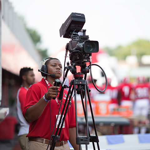 Student behind camera at sporting event