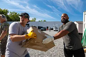 Volunteers helping Yaipak move supplies