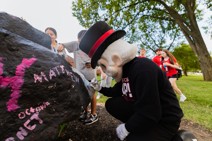 Gov Mascot helping to paint the Spirit Rock