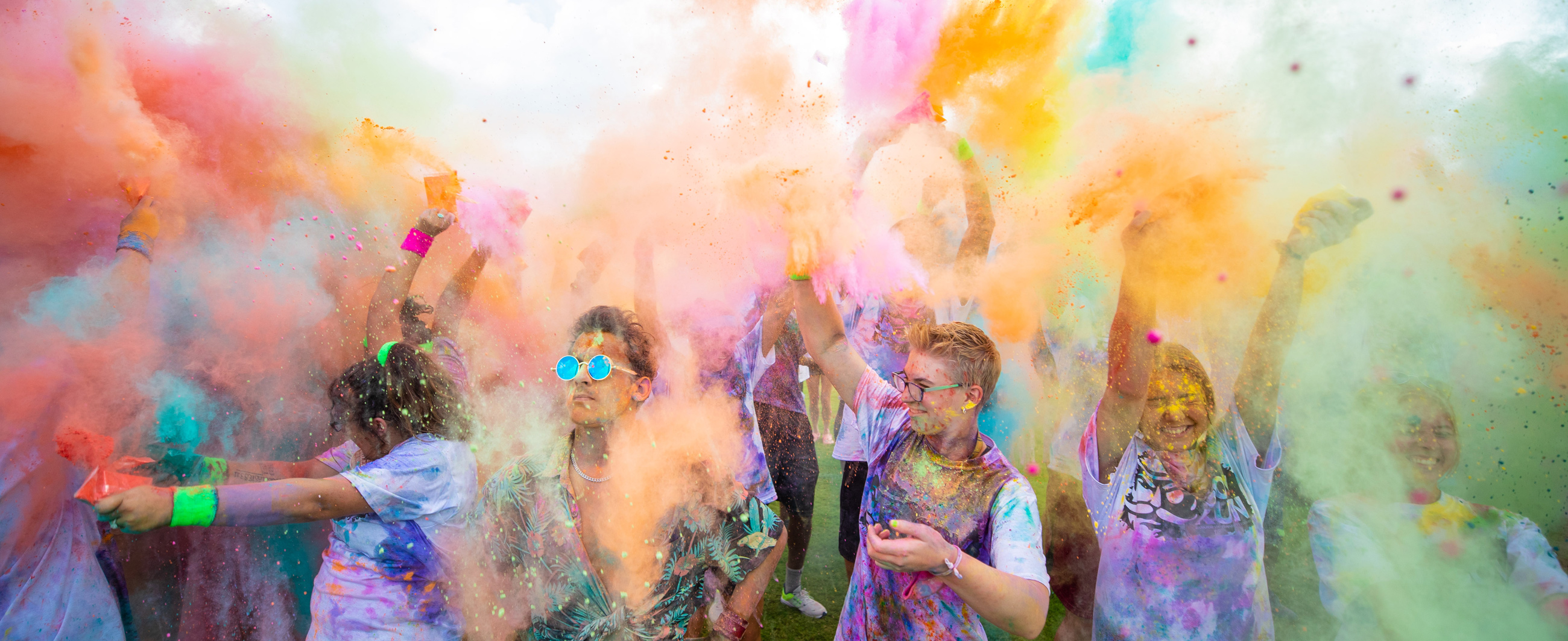 Students throwing colored powder during Govs Color Run.