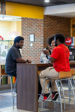 Student talking at a table in Einsteins.